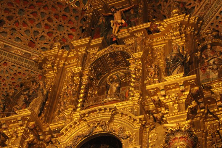 Ático del retablo con las tallas de Santo Domingo, Santa Rosa de Lima y Santa Margarita de Saboya. Sobre ellas se sitúan además las tallas que representan el Calvario